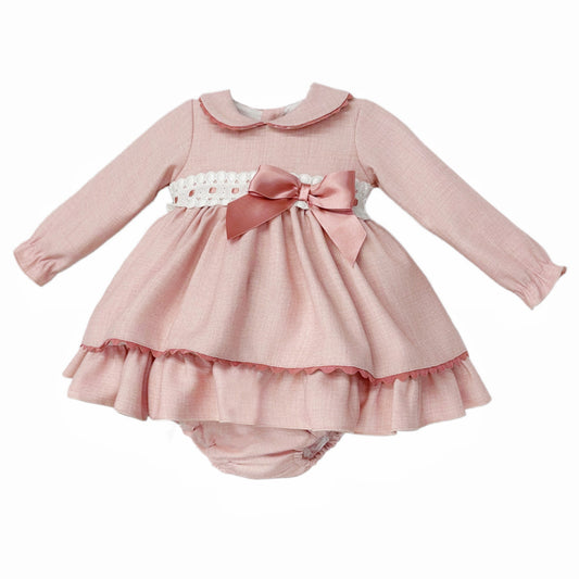 Angled view of pink dress and pants showing ribbon-threaded broderie waist, side bow and frilled hem
