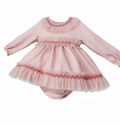 Angled view of the pink dress and pants set showing sheer neckline, waist and hem frills