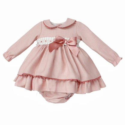 Angled view of pink dress and pants showing ribbon-threaded broderie waist, side bow and frilled hem