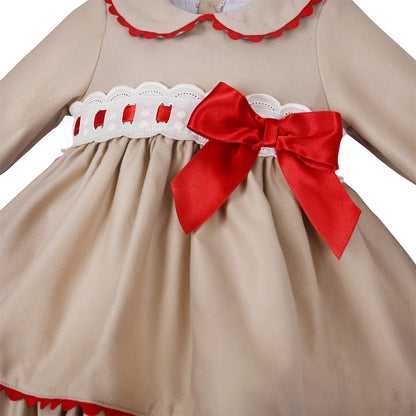 Close-up of red ribbon threaded through the white waist band beside the large red bow