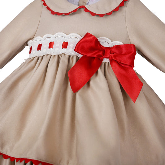 Close-up of red ribbon threaded through the white waist band beside the large red bow