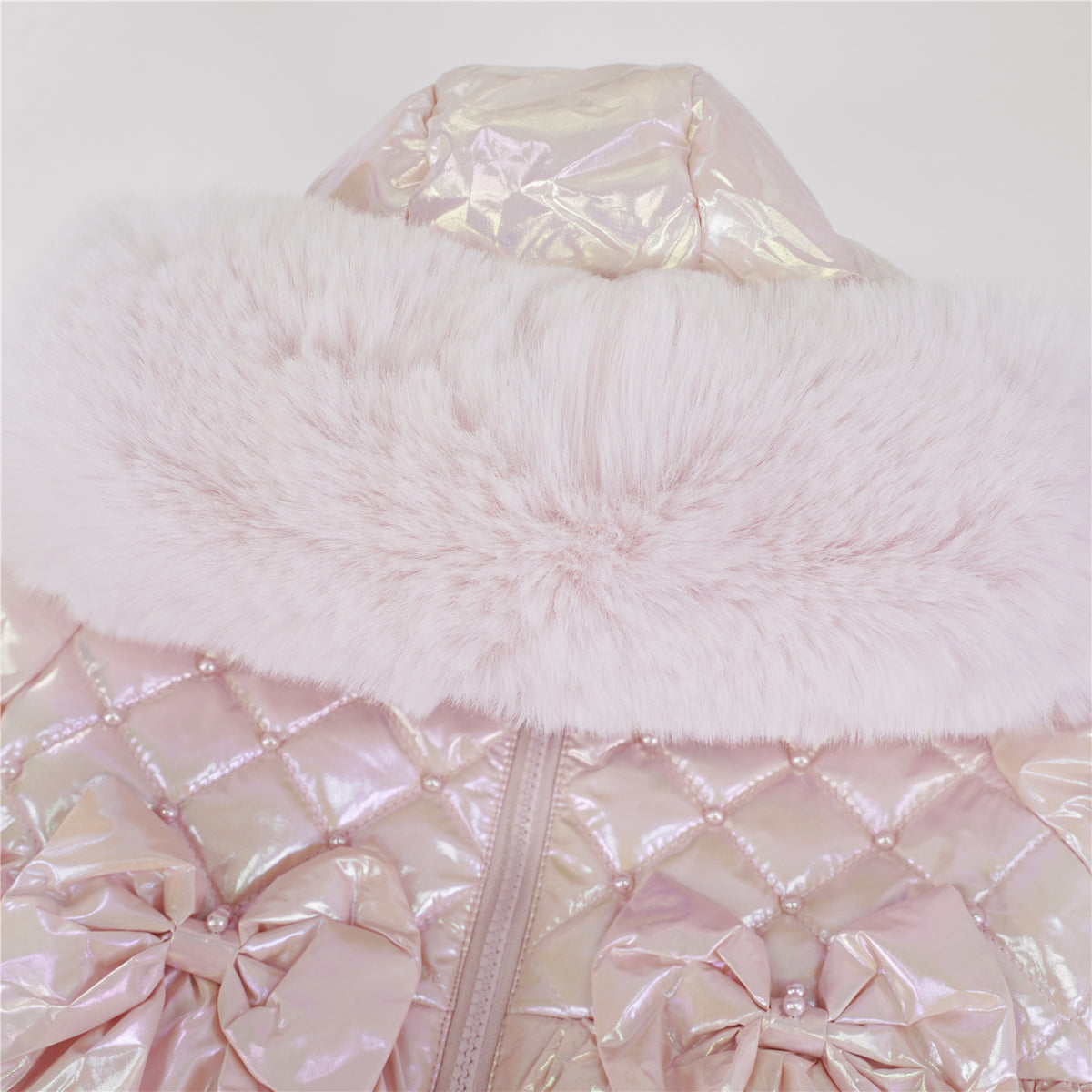 Close-up of pink faux-fur hood trim, bead-detailed quilting and matching waist bows