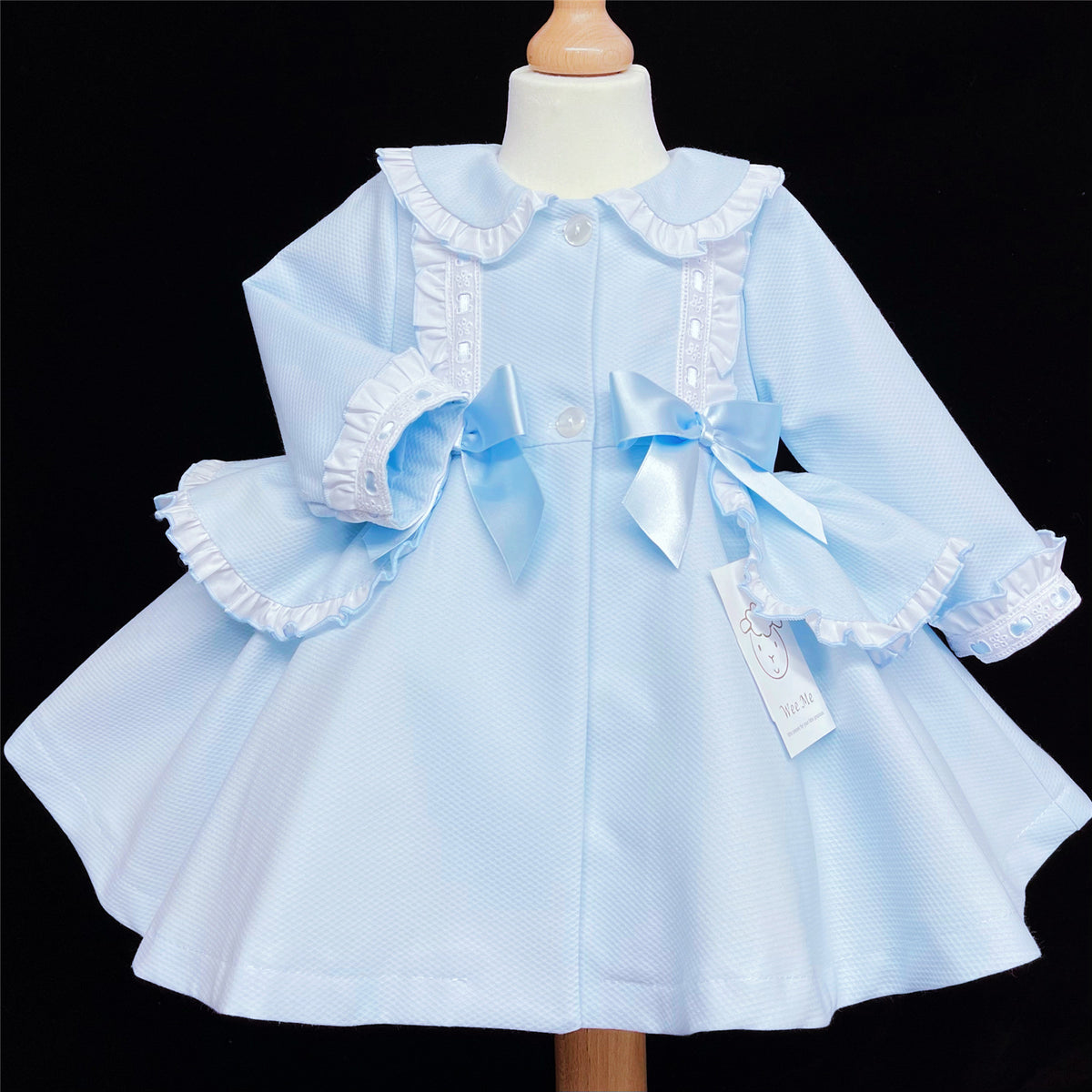 Pale blue baby girls jacket with twin front bows and a ruffled collar