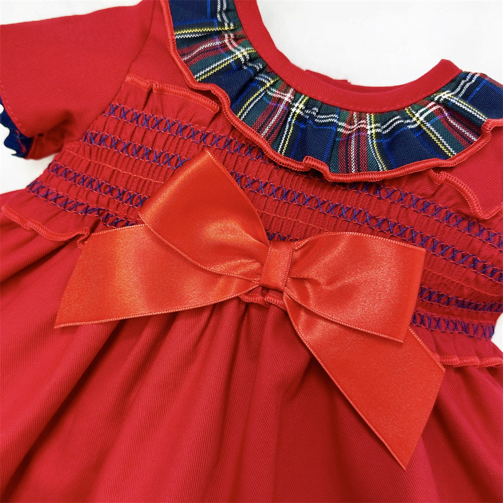 Close-up of the tartan frill neckline, smocking and satin-look bow on the red dress